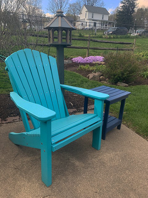 adirondack chair in Aruba blue, end table in blue, bird feeder in green on weathered wood.